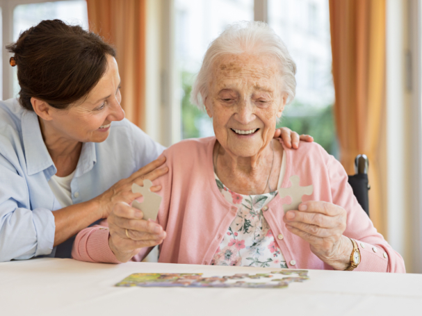 Happy senior woman in wheelchair with caregiver